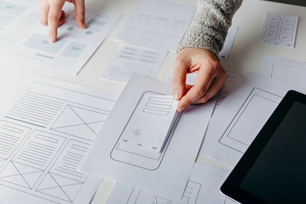 Arbeitssituation mit Prototypen aus Papier in der Frühphase von Softwareentwicklung