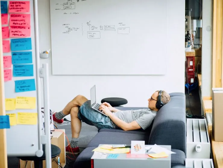 Bild eines Mitarbeiters auf dem Sofa mit dem Laptop auf dem Schoß